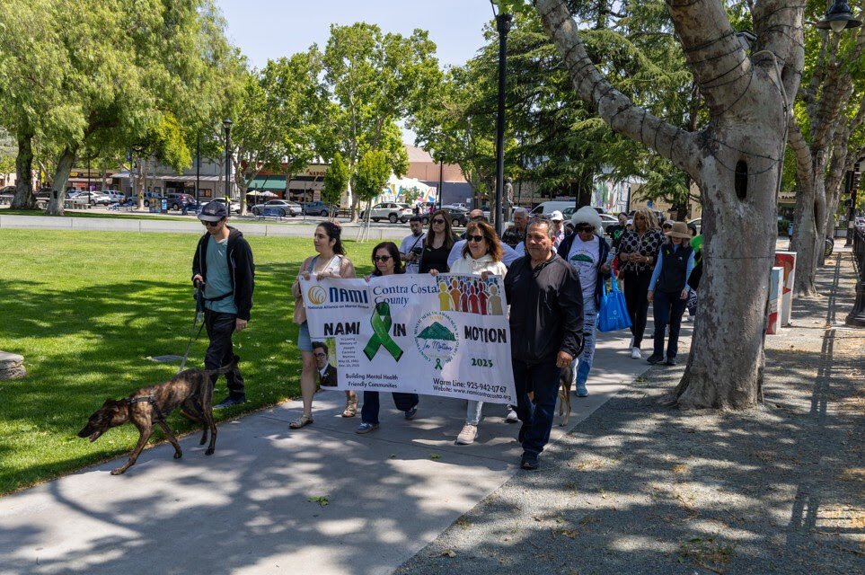 people holding up a banner and walking around a park